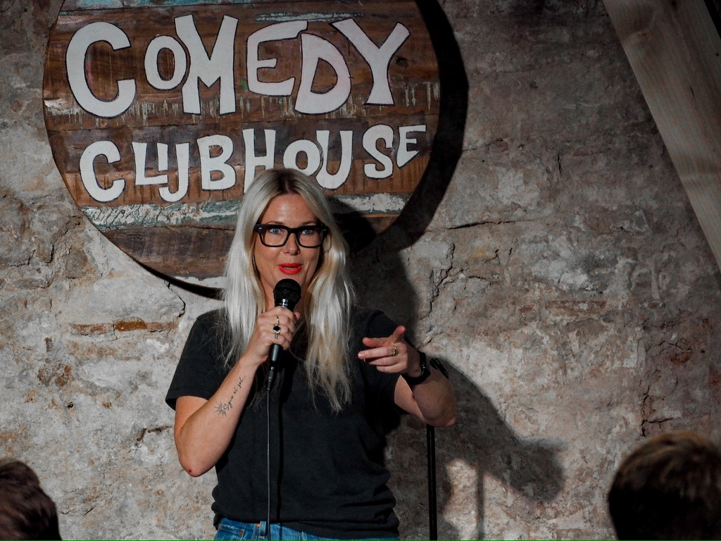 Michelle Ahern performing in a black top at the Comedy Clubhouse