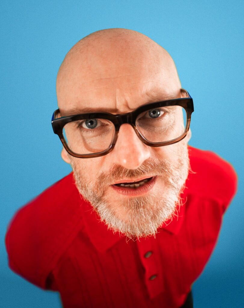 Alec Snook looks at camera against blue background